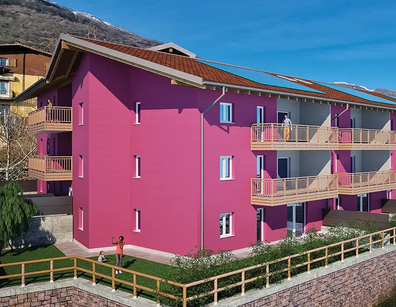 Render della Residenza Alessia a Pedersano: edificio fucsia con balconi in legno e giardino