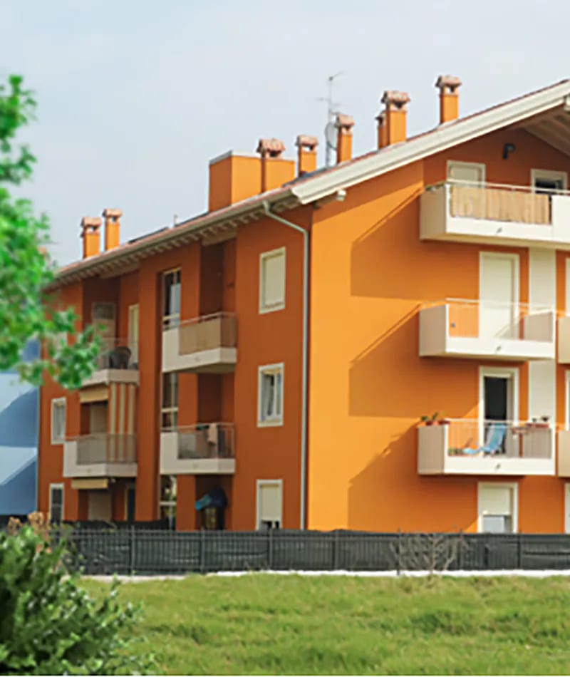 Residenza Alessandra a Rovereto: condominio arancione con balconi e prato davanti