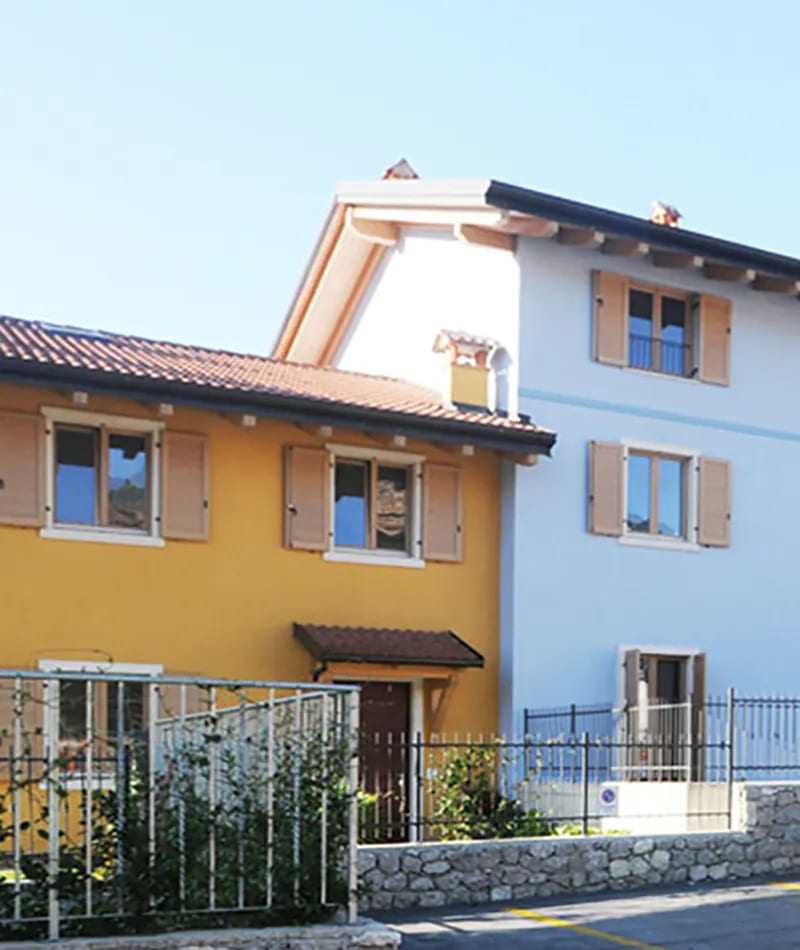 Residenza Amarilli: case a schiera gialla e bianca con persiane in legno e muretto in pietra