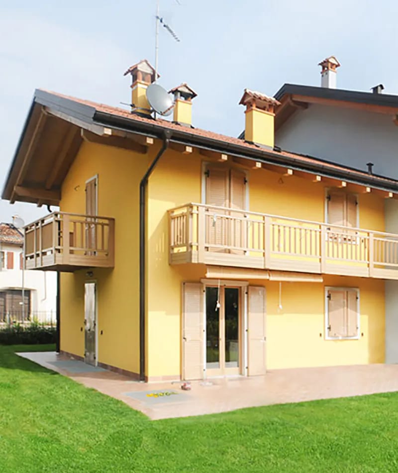 Residenza Amarilli: casa gialla con balconi in legno, terrazzo e prato