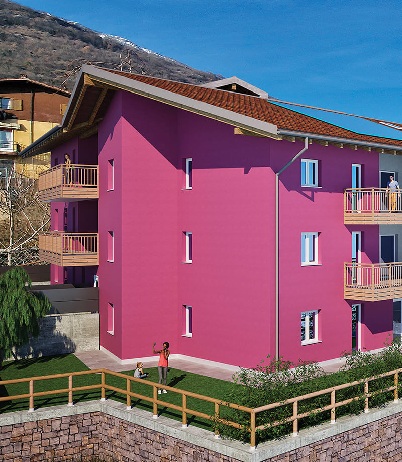 Render della Residenza Alessia a Pedersano: edificio fucsia con balconi in legno e giardino recintato